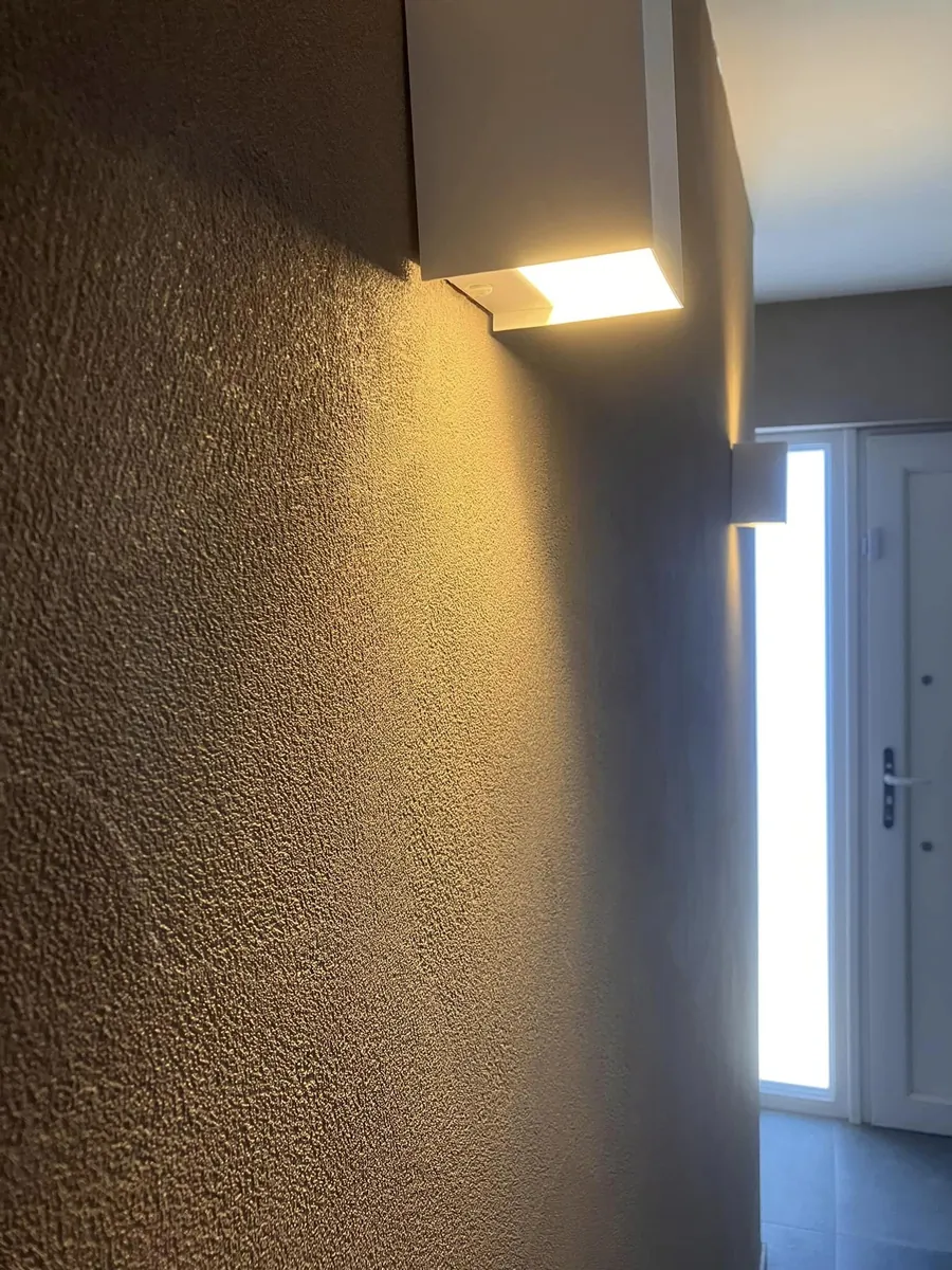 Gang met textuurwand en wandverlichting